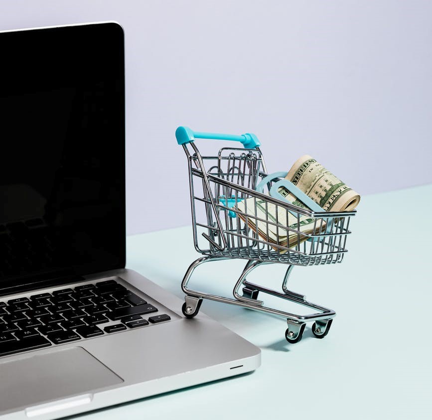 A shopping cart on top of a laptop