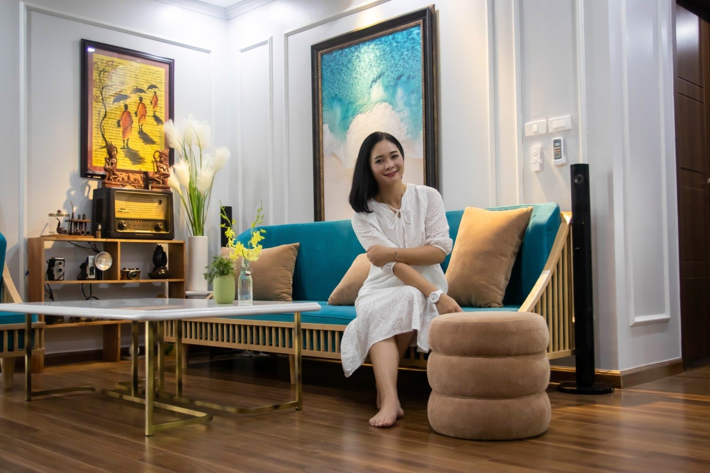 hình ảnh một phụ nữ trẻ tuổi ngồi trên ghế sofa phòng khách căn hộ