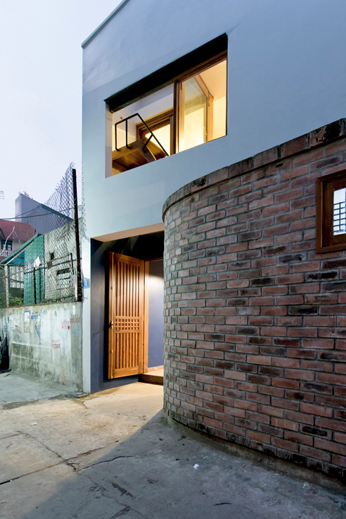 Phần tường gạch mộc được thiết kế để tạo điểm nhấn cho khoảng sân trước