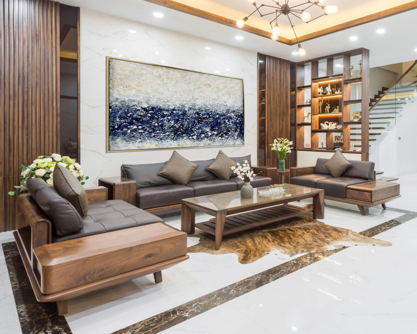 Không gian tiếp khách được bài trí sang trọng, sử dụng nội thất gỗ chủ đạo kết hợp hài hòa với đèn chùm trang trí ấm áp.