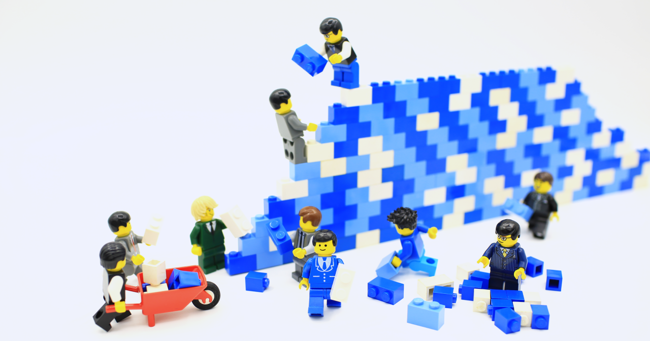 Lego minifigures building a construction from lego bricks