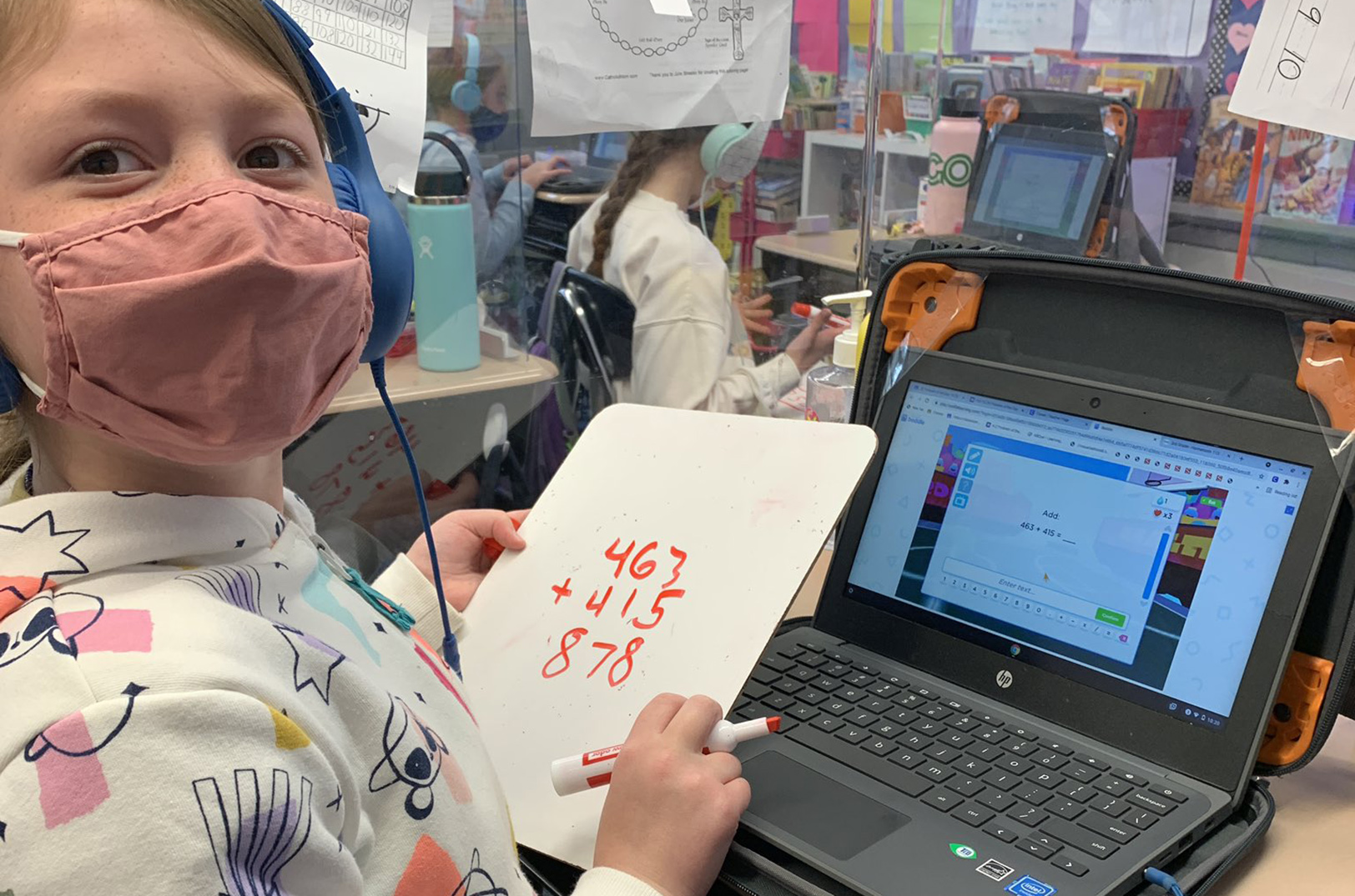 A student wearing a mask practices math with Boddle.
