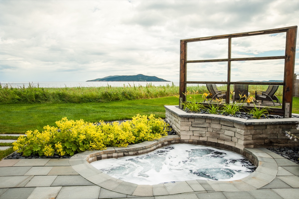 Aménagement d'un spa intégré avec muret et patio de pierre naturelle