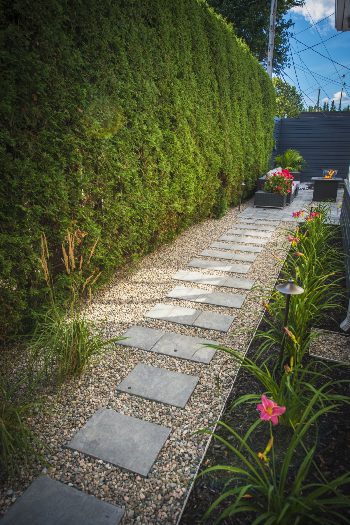 Trottoir en pas de jardin en pavé dans une zone de pierre de rivière
