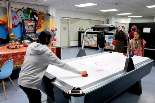 Kids play air hockey at The Hub.