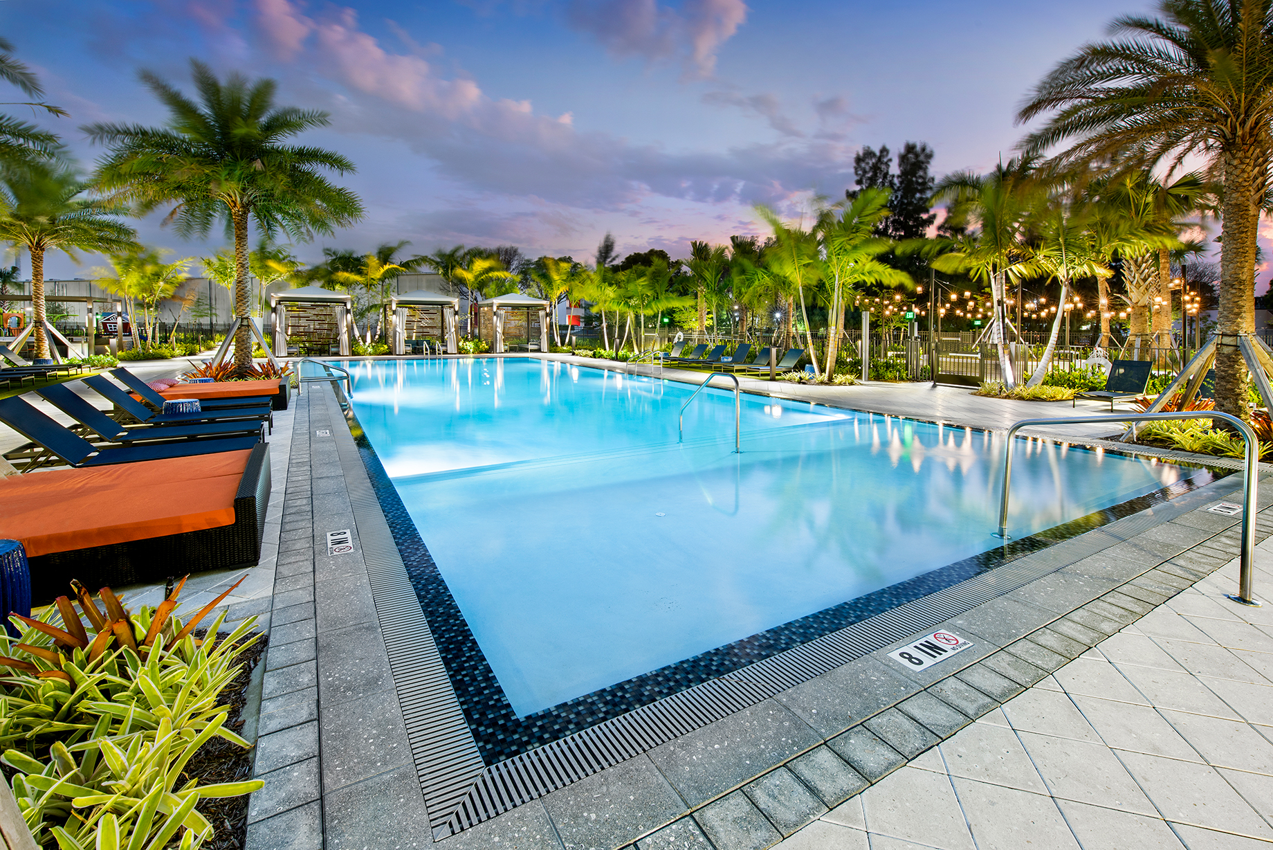 Large Pool with cabanas and daybeds during the evening