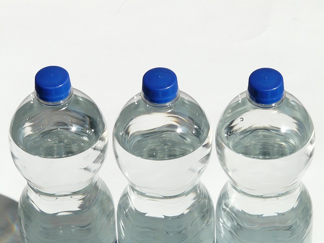 Three water bottles with blue caps