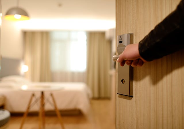 Person opening a door to enter a hotel room