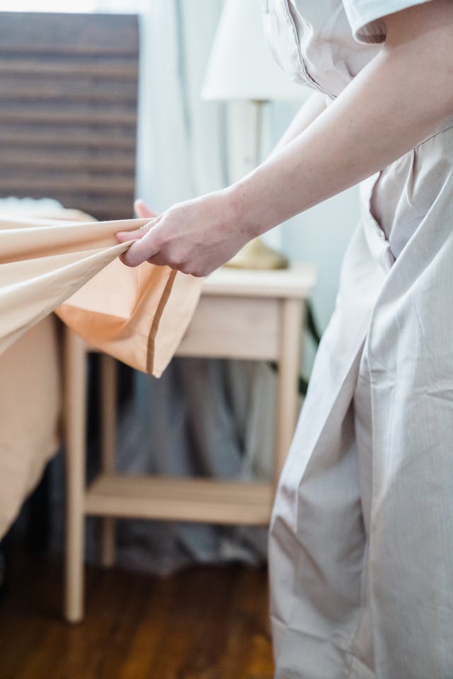 person inspecting their sheets for bed bugs
