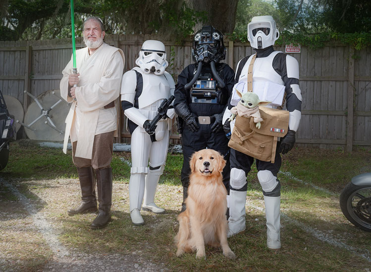 Star Wars characters from the 501st Legion standing with a Golden Retriever.