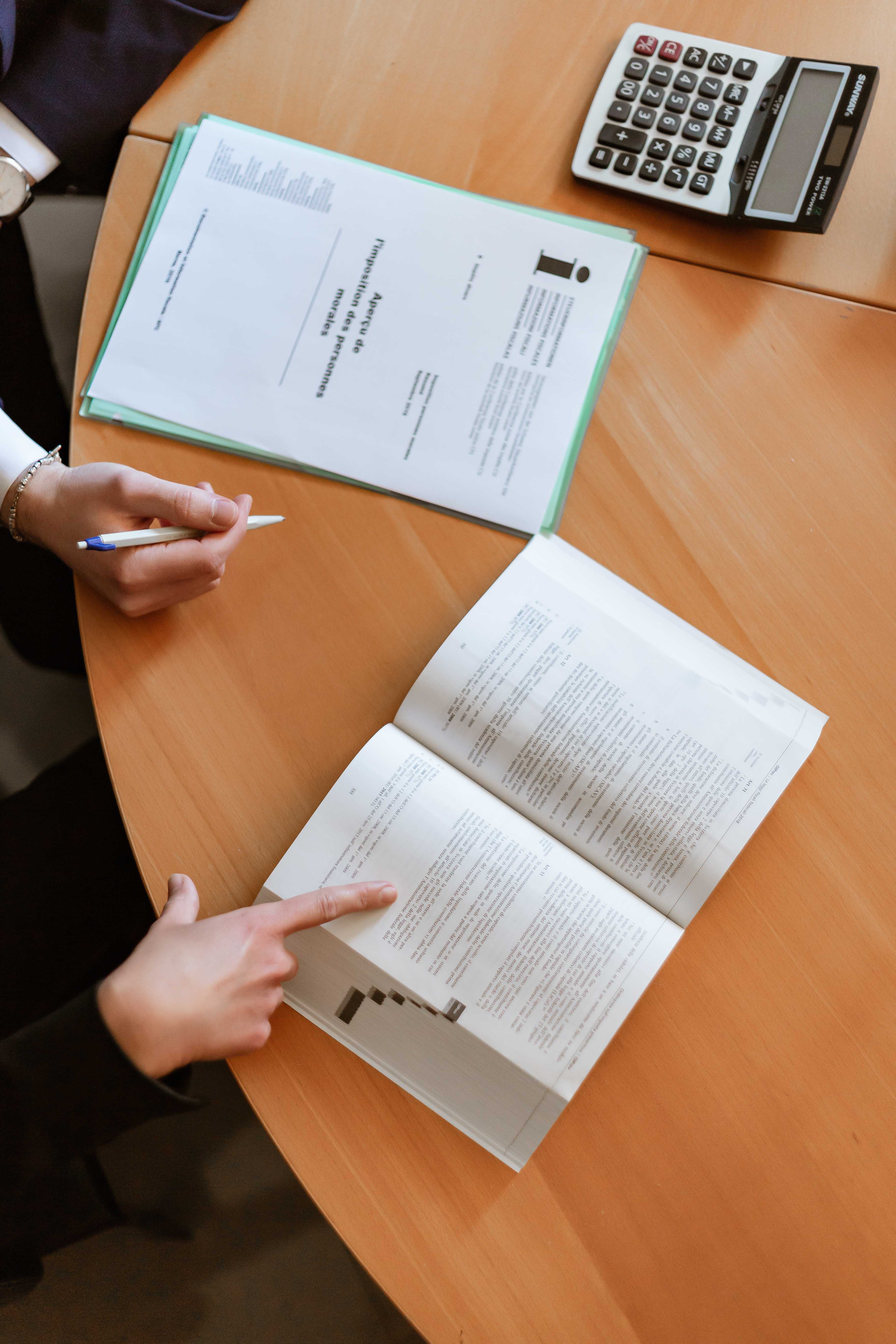 Photo of two hands pointing at files and books