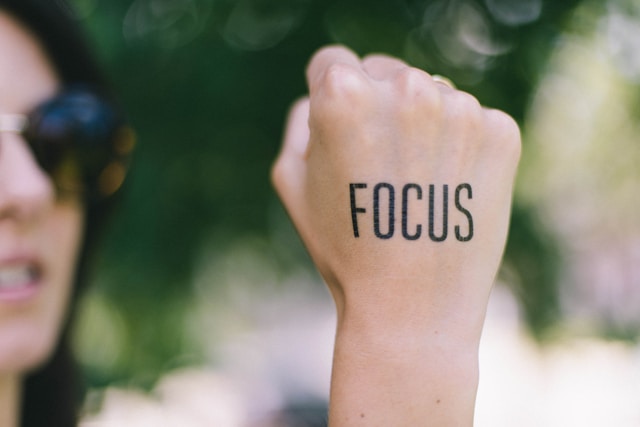 A woman's hand with 'focus' written on it