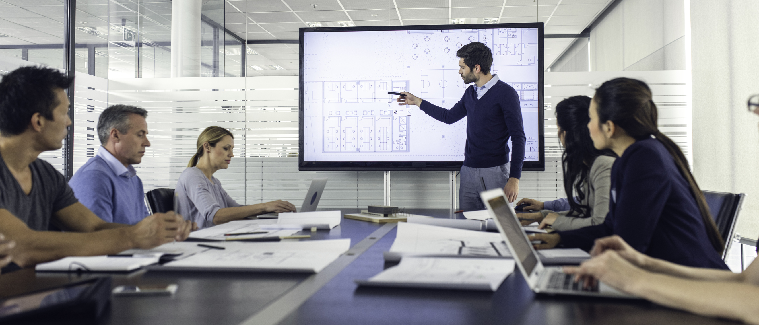 man pointing to floorplans on interactive touchscreen