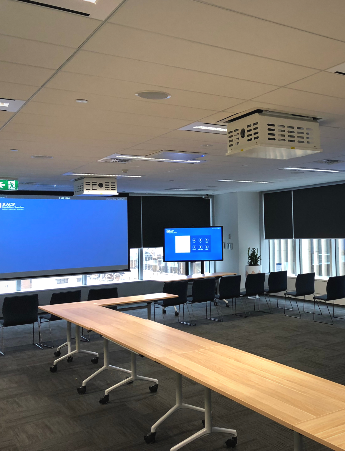 video conference boardroom with TV screens on wall