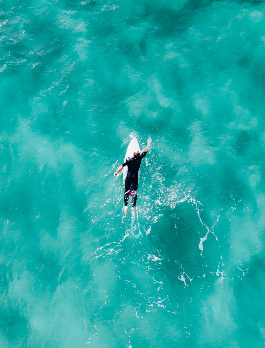 Person paddling out to sea on surfboard