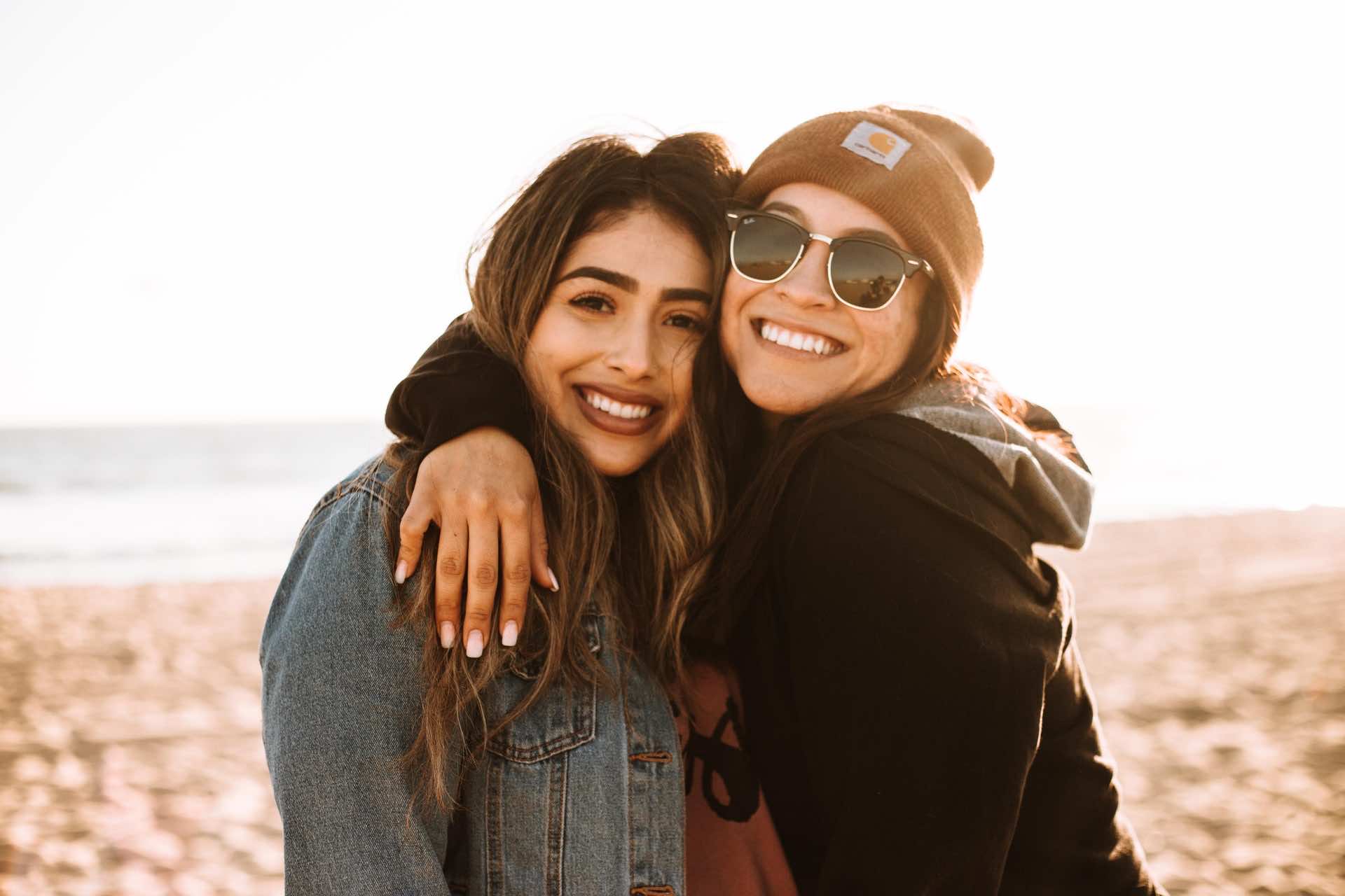 Two girls hugging at sunset