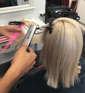 Keratin being heat infused into blonde hair.