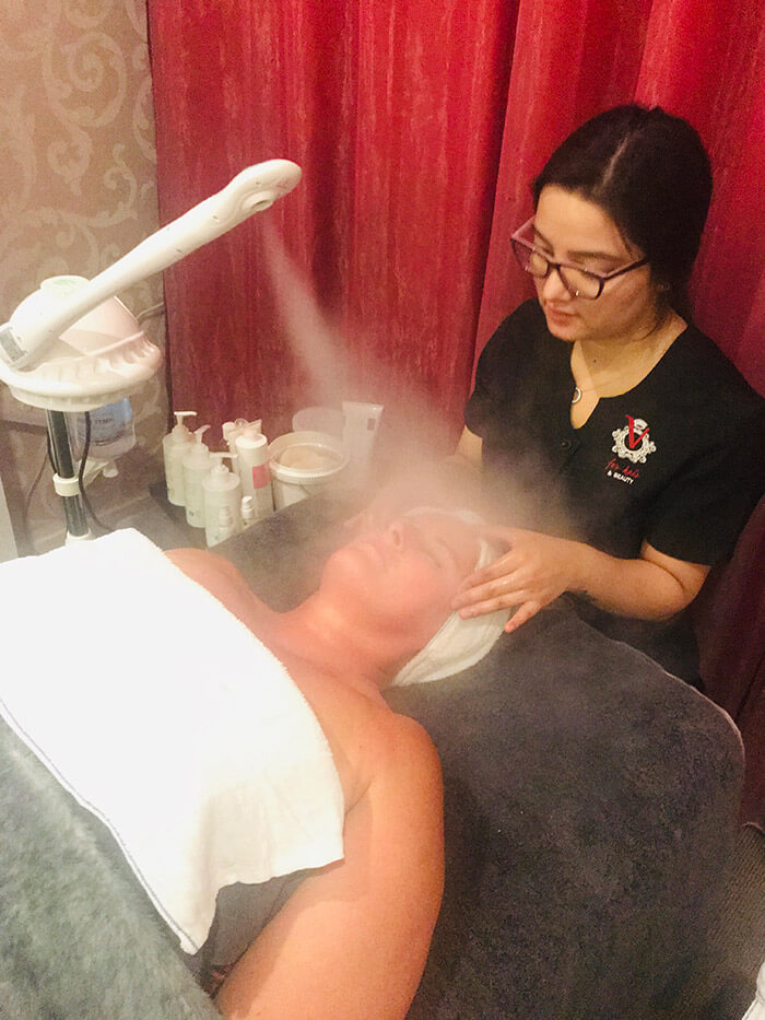 Vicki receiving The Deluxe Exfoliating Steam facial.