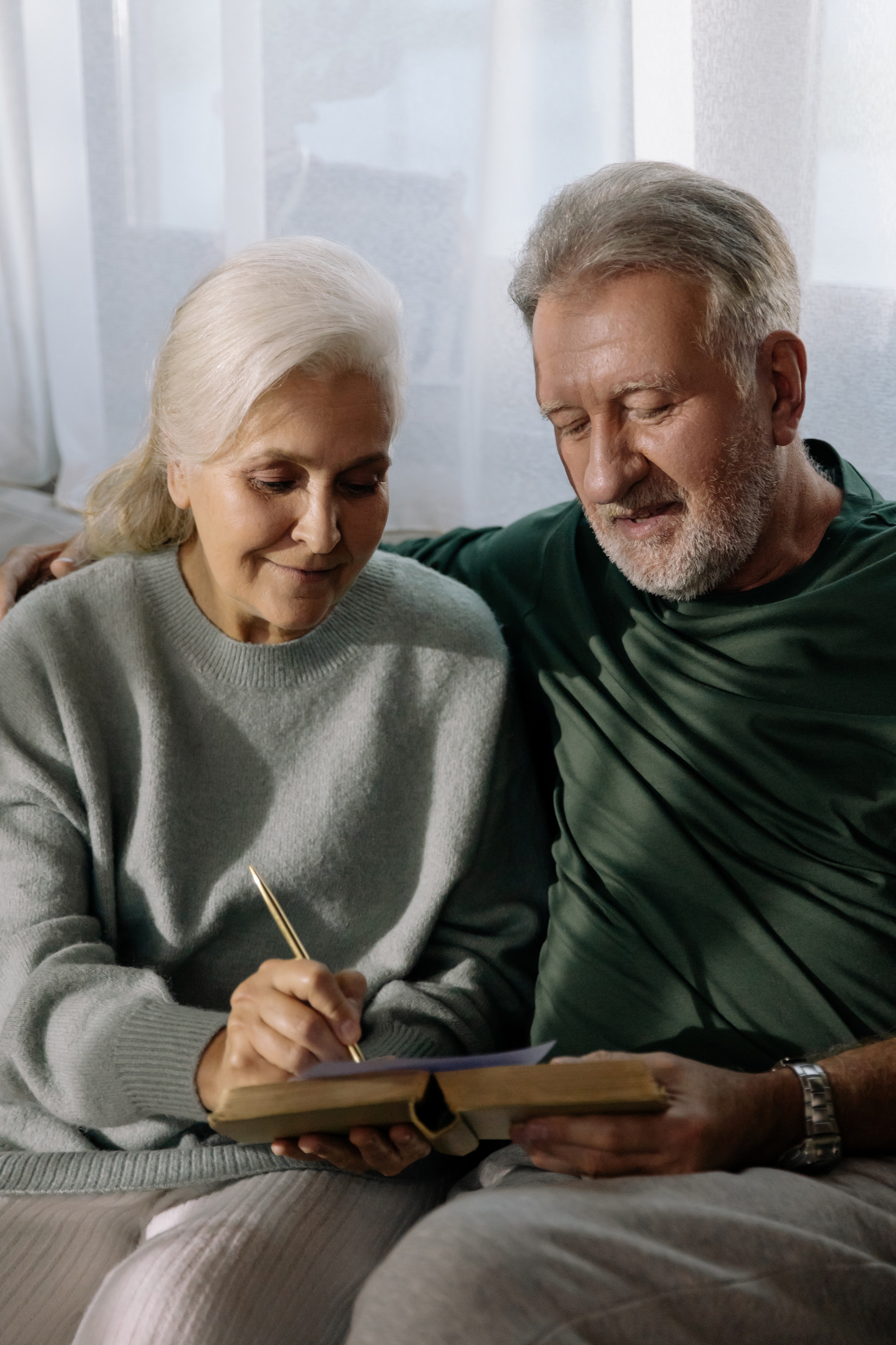 Two elderly people reading together