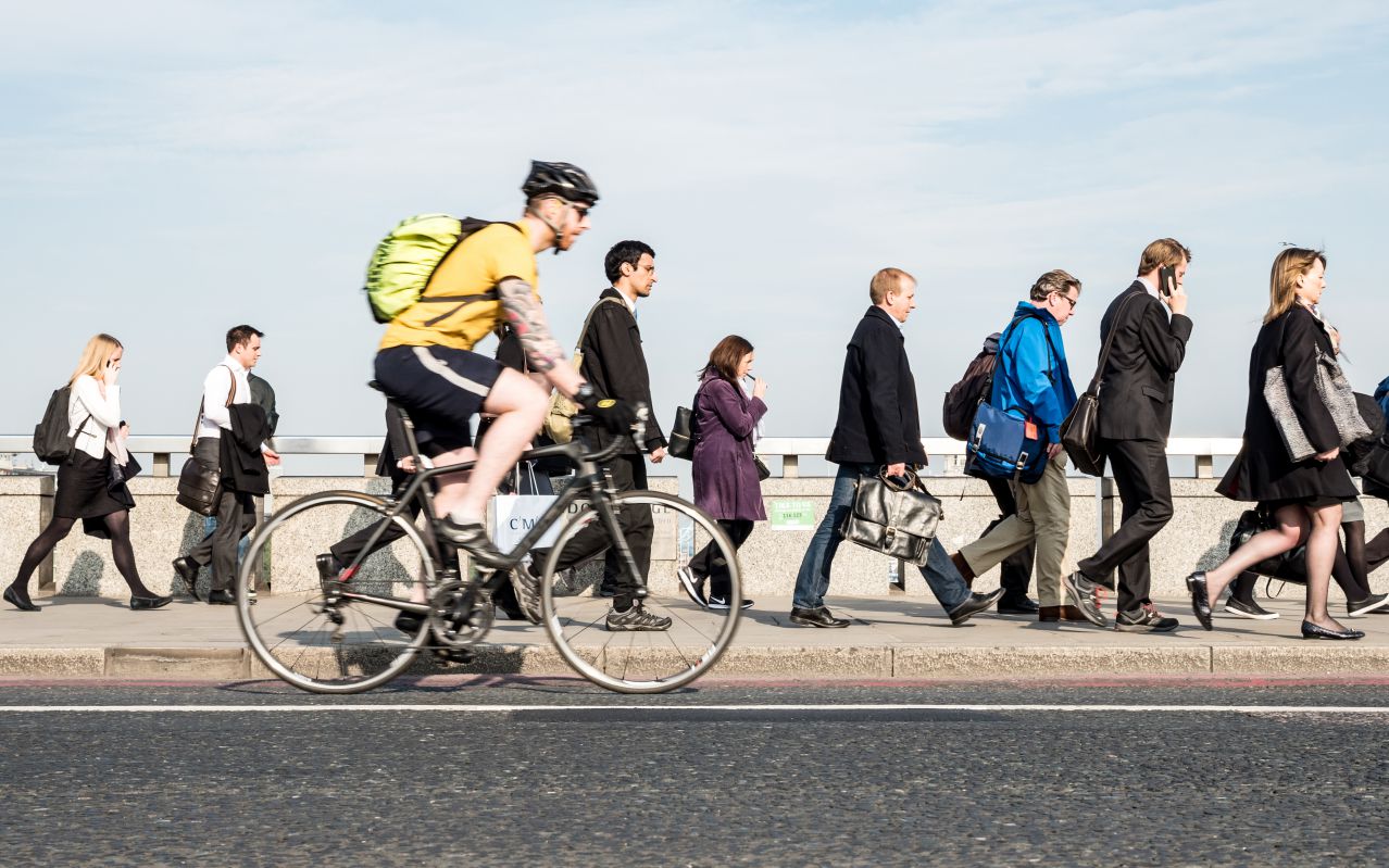 Menschen zu Fuß und mit dem Fahrrad auf dem Weg zur Arbeit