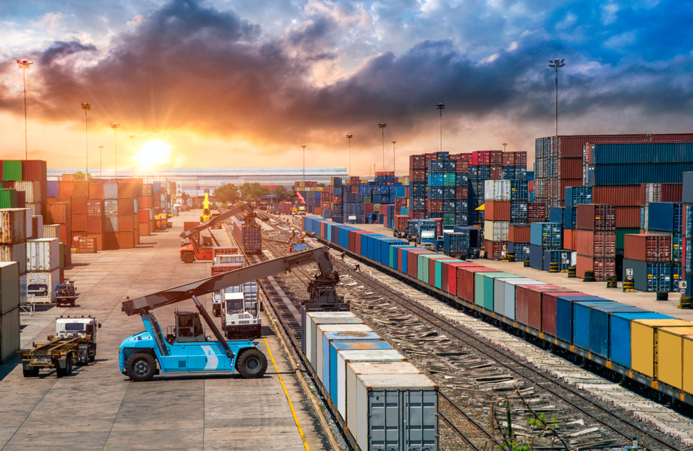 Container werden am Umschlagbahnhof mittels Ladefahrzeuge auf die Schiene geladen
