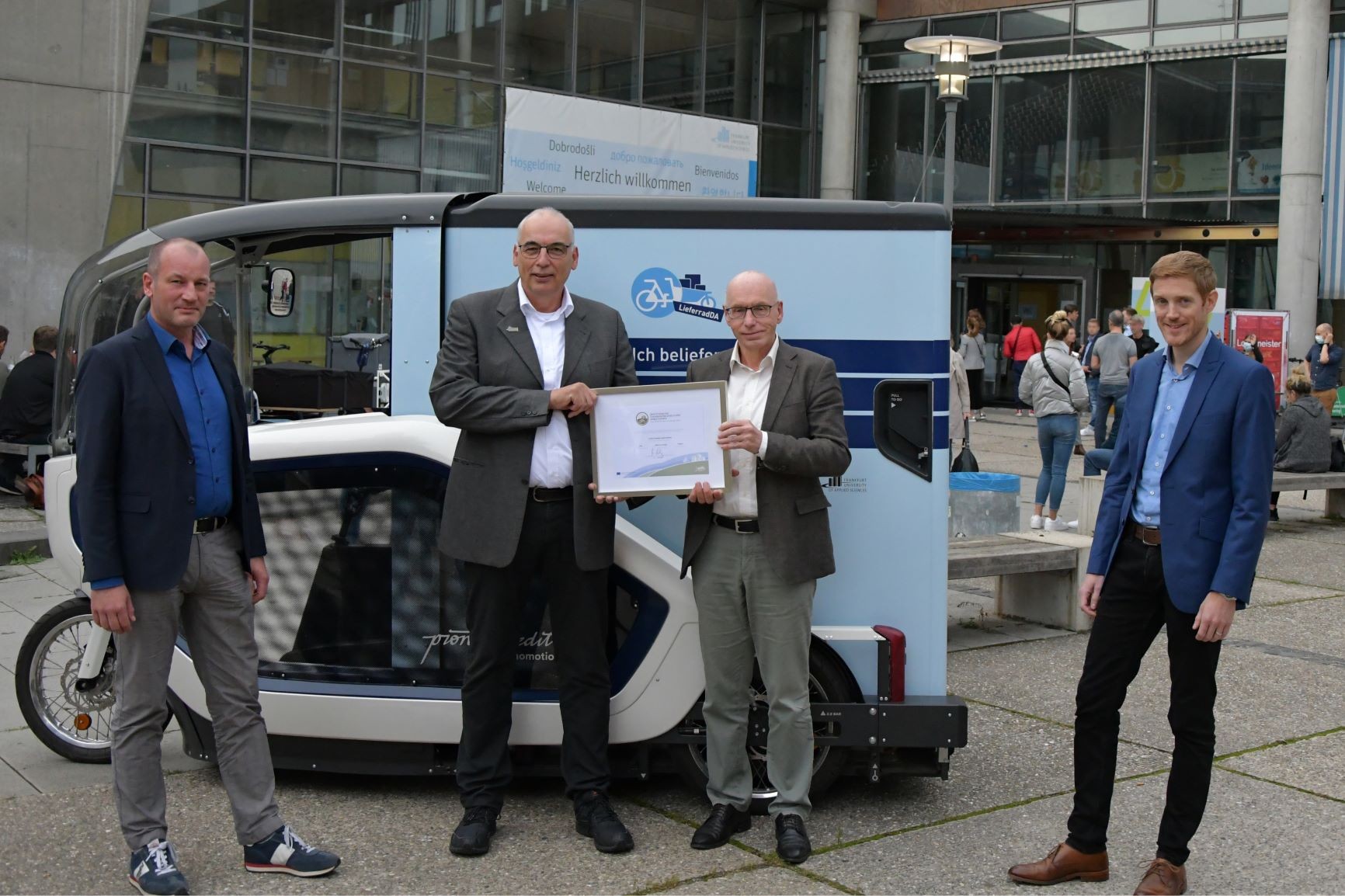 Gruppenfoto von vier Männern mit Urkundenübergabe