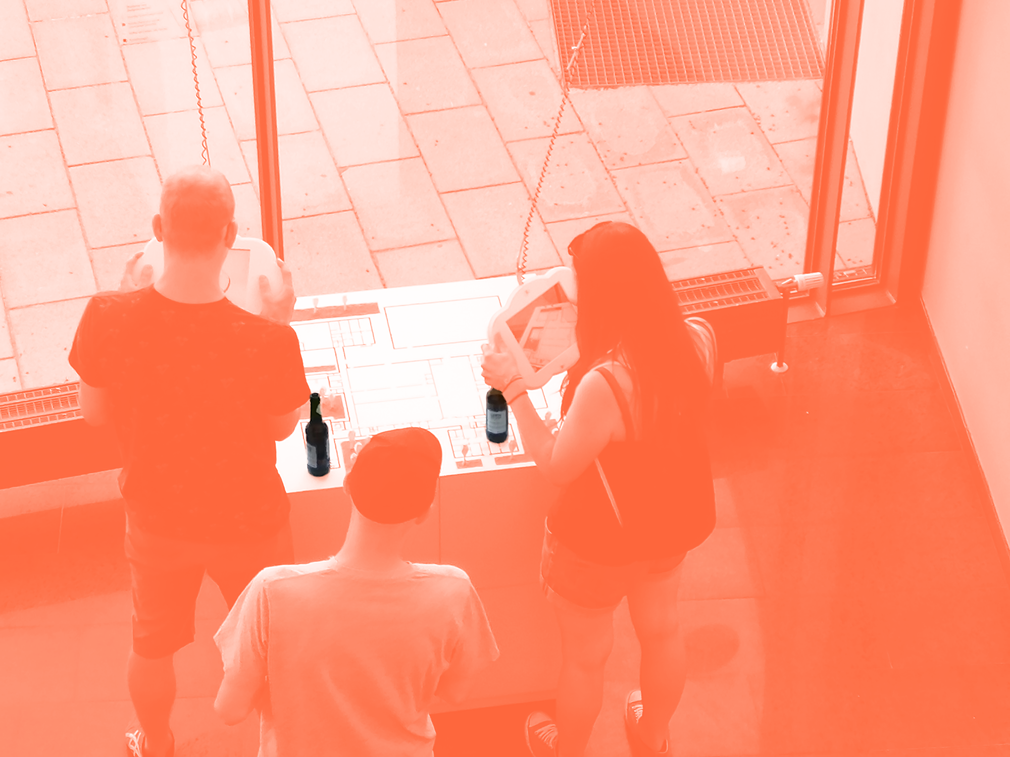 Image of people having placed their beverages on the exhibit while using it.