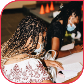 A young woman listening and taking note while Aarian, Co-Founder, Xceleader speaks during a wokrshop