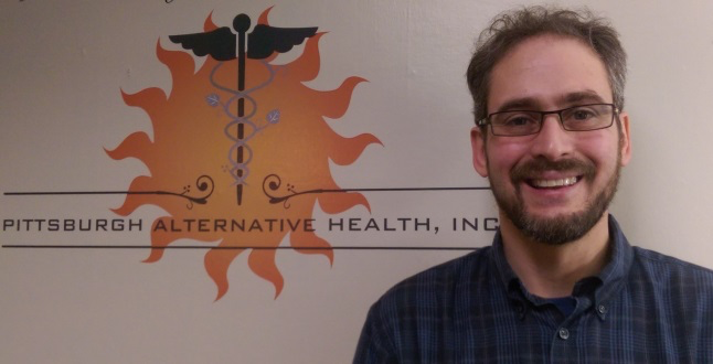 Darrell standing in front of Pittsburgh Alternative Health sign