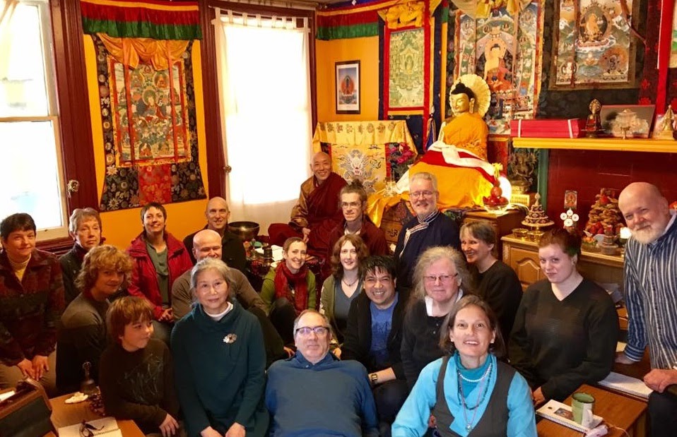 Group of people kneeling on floor of Tibetan meditation room