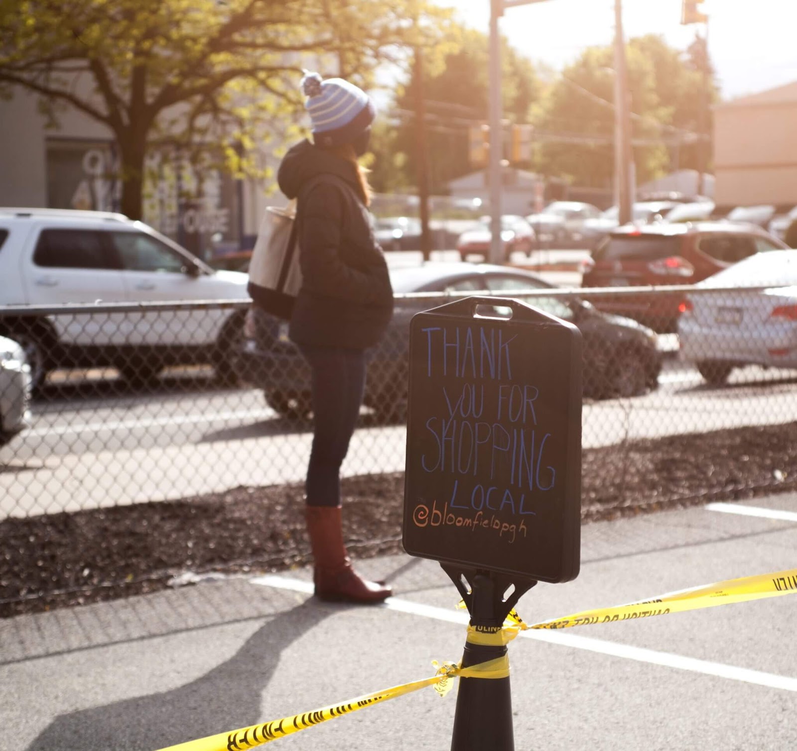Woman standing on sidewalk in front of sign