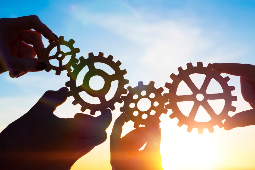 four hands connecting gear pieces