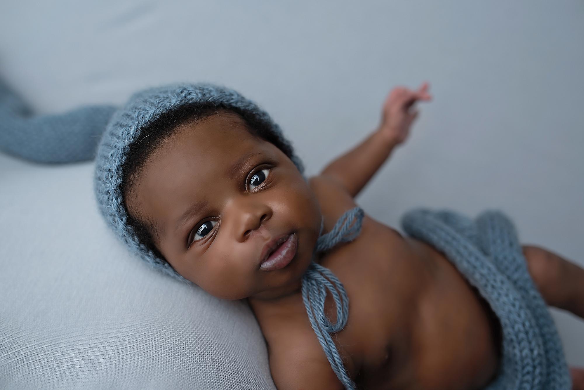 A wide-eyed newborn baby