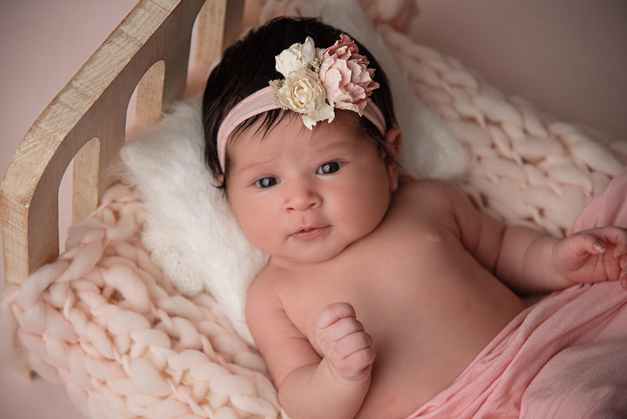 A wide-eyed newborn baby