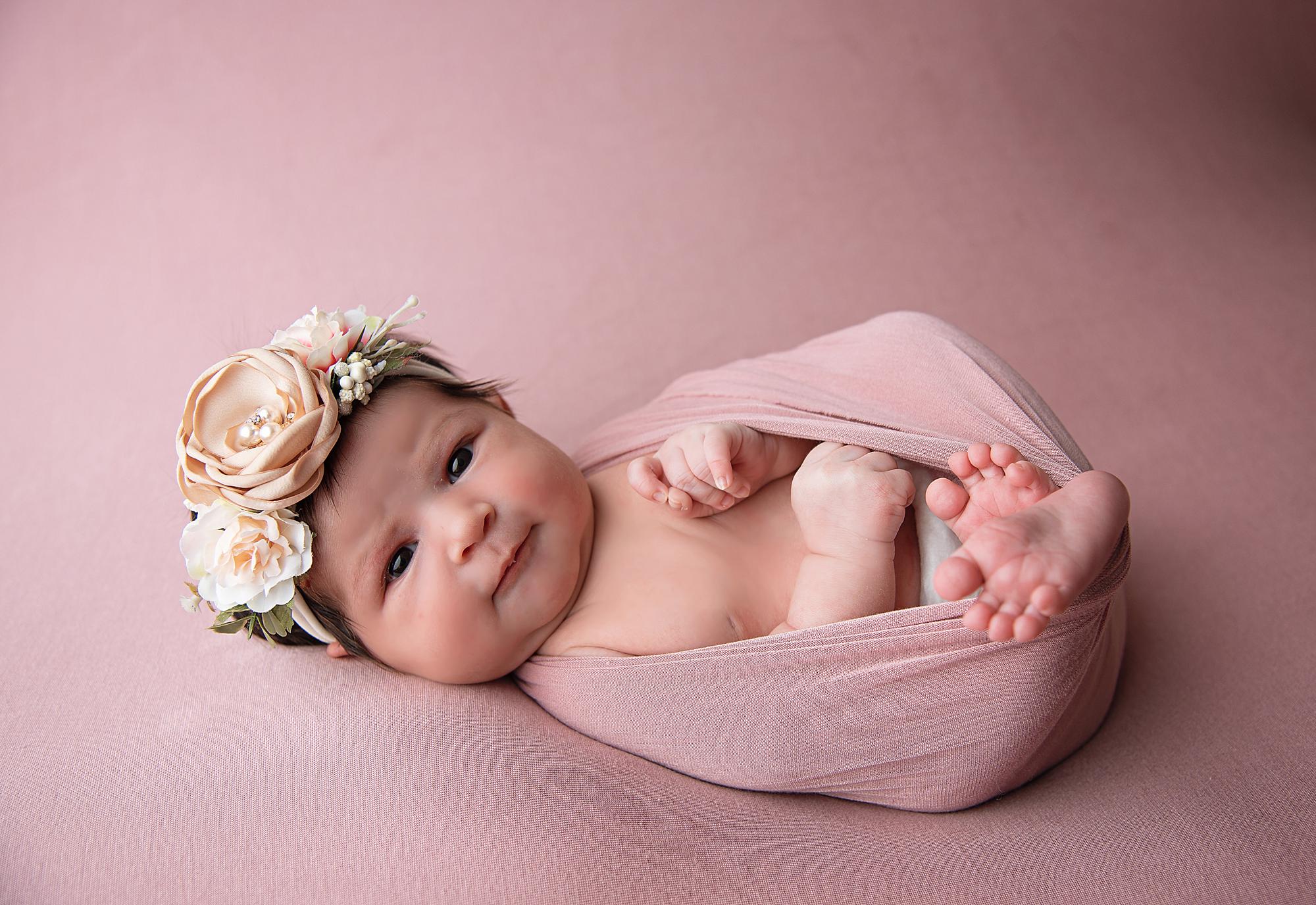 A wide-eyed newborn baby