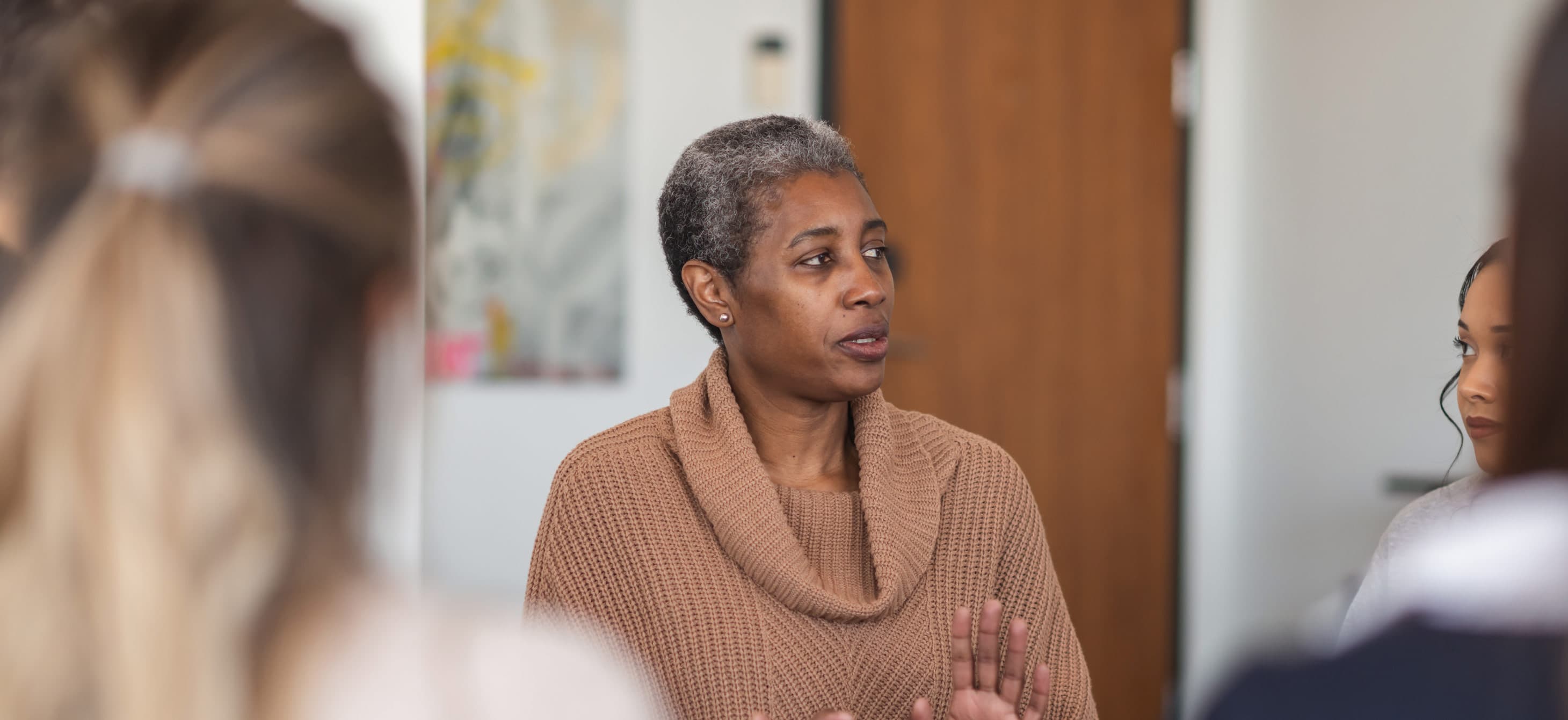 a Black woman leading a group meeting