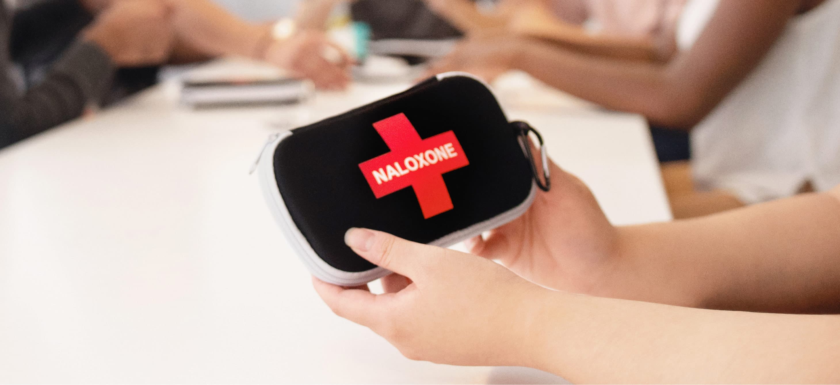 hands holding a Naloxone kit