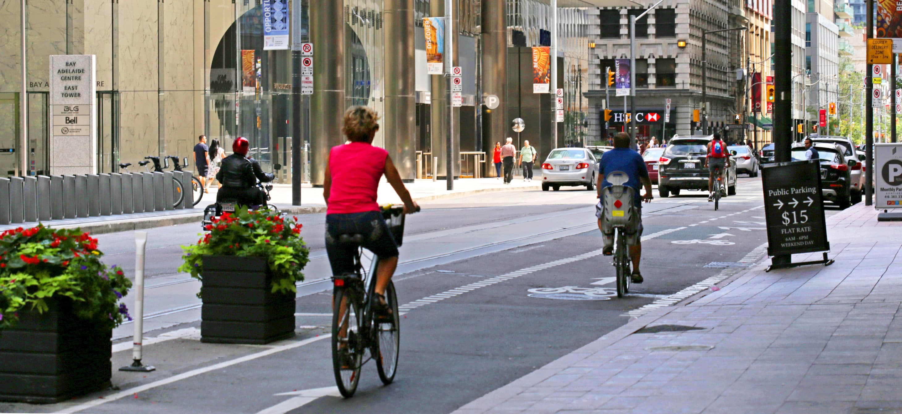 downtown street that has a sidewalk, a separated bike lane, and car lanes