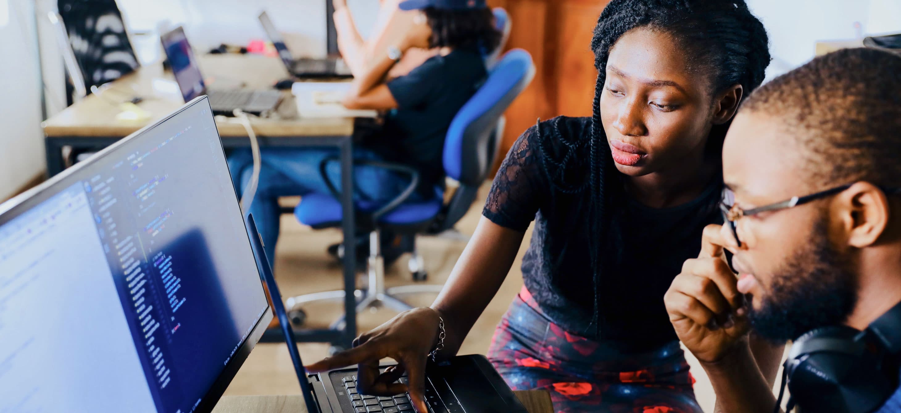 two Black students looking at a computer screen together