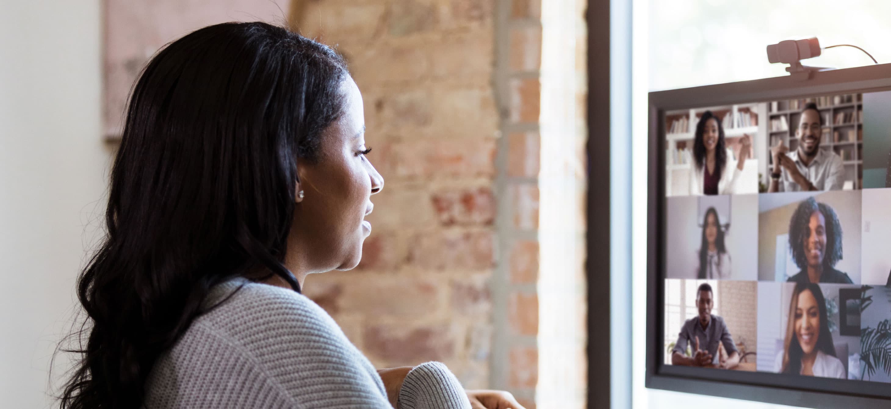 a Black woman participating in a Zoom call with other Black participants