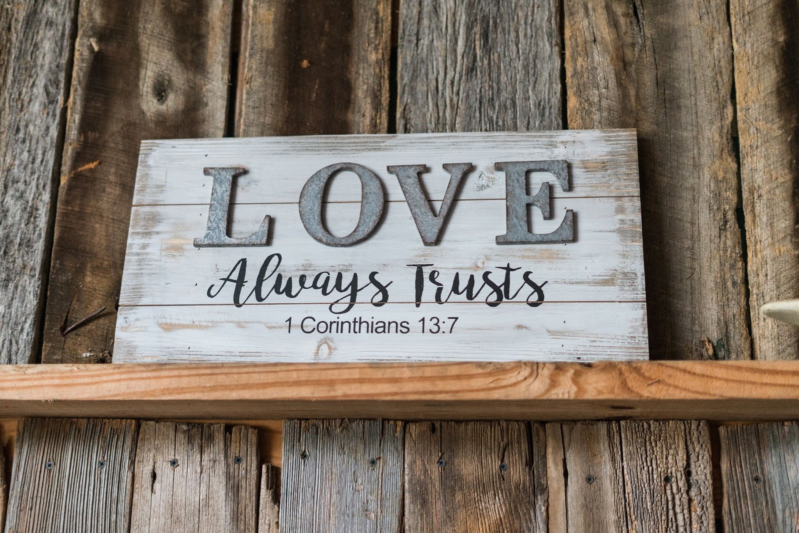 A Bible verse from 1 Corinthians 13:7 displayed in the home