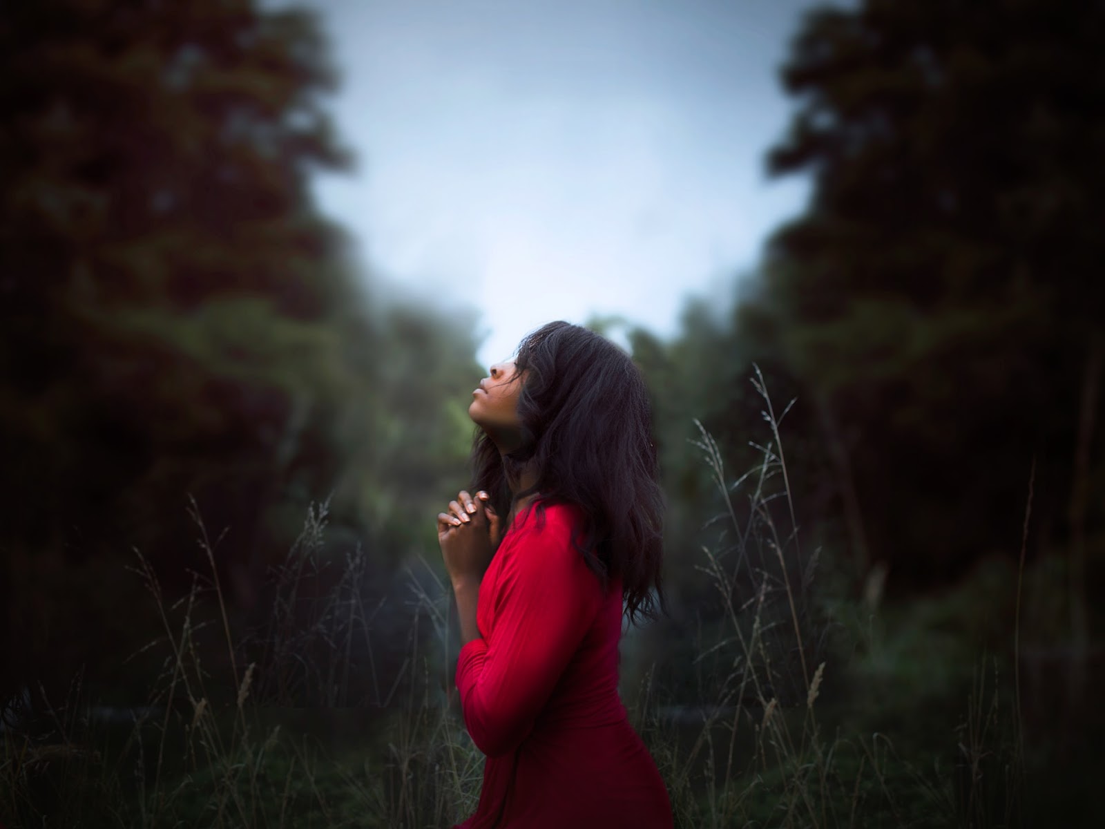 woman praying in the woods