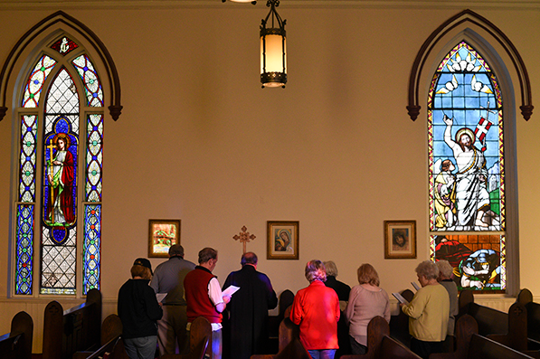 people inside a church at one of the stations of the cross