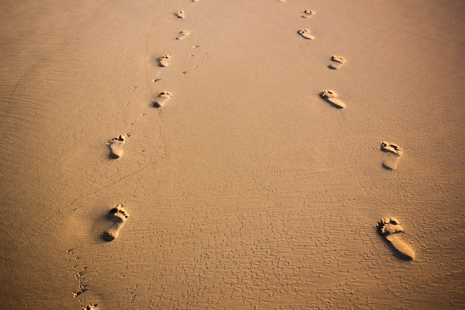 two pairs of footsteps in the sand