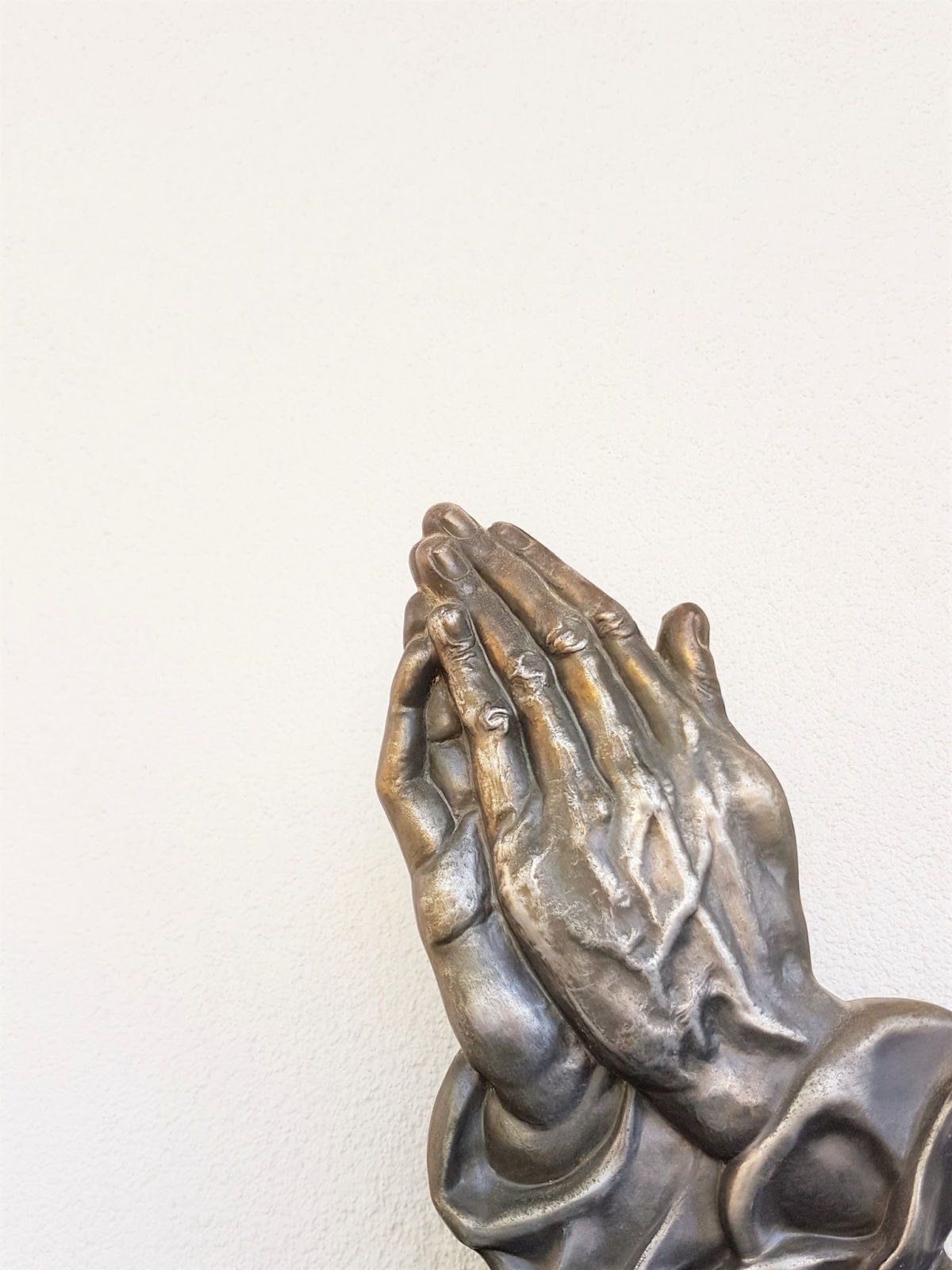 metal hands in prayer