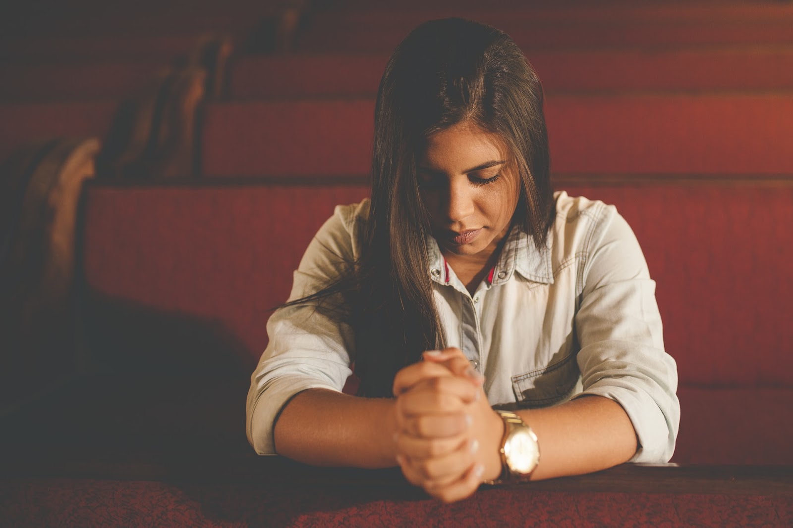 a woman with her head bowed in prayer