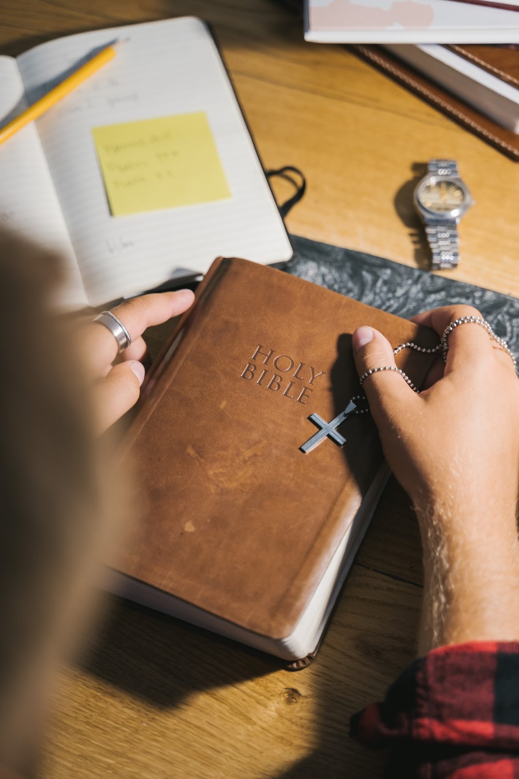 person holding a bible and a cross