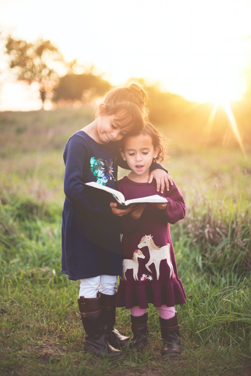 two little girls looking at a book