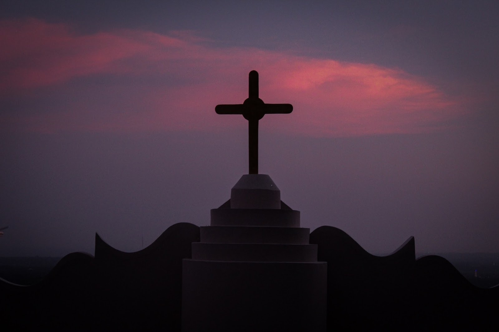 silhouette of cross on a roof at night