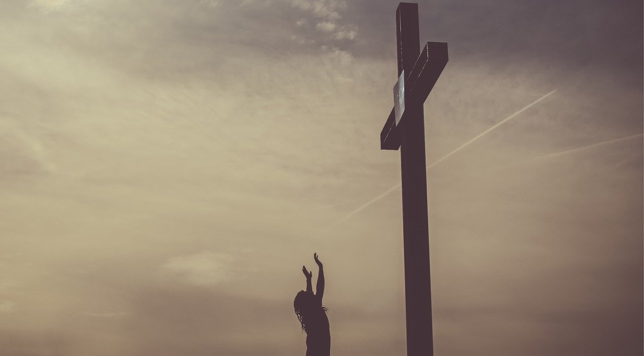 Woman hands raised to a cross